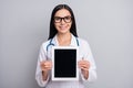 Photo of doctor woman hold tablet show screen empty space wear stethoscope glasses white uniform isolated grey color Royalty Free Stock Photo