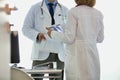 Doctors discussing over medical records at desk in hospital