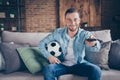 Photo of domestic handsome guy stay home quarantine time watch football match champion league europe hold leather ball Royalty Free Stock Photo