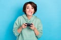 Photo of doubtful uncertain lady dressed green pullover biting lip holding play station isolated blue color background