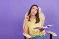 Photo of dream young brunette lady look empty space write sit on armchair wear top isolated on violet color background