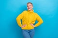 Photo of dreamy adorable girl dressed knitwear pullover looking hands waist looking empty space isolated blue color