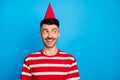 Photo of dreamy cheerful young man wear birthday cone hat look empty space isolated on pastel blue color background