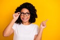 Photo of dreamy cute woman wear white t-shirt arm spectacles looking showing finger empty space isolated yellow color Royalty Free Stock Photo