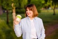 Photo of dreamy cute young lady wear blue shirt smiling walking enjoying tasty tea, coffee bamboo eco cup in green park Royalty Free Stock Photo