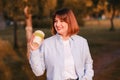 Photo of dreamy cute young lady wear blue shirt smiling walking enjoying tasty tea, coffee bamboo eco cup in green park Royalty Free Stock Photo