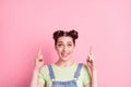 Photo of dreamy girl indicate forefinger empty space look up wear jeans overall green t-shirt isolated on pink Royalty Free Stock Photo