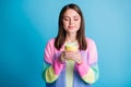 Photo of dreamy happy brown haired young woman drink coffee hold mug closed eyes isolated on blue color background Royalty Free Stock Photo