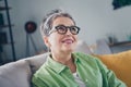 Photo of dreamy intelligent elderly woman wear khaki green shirt deep thinking look above sitting couch waiting in