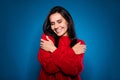 Photo of dreamy pretty young woman dressed red pullover hugging herself smiling closed eyes isolated dark blue color Royalty Free Stock Photo