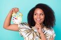 Photo of dreamy shiny dark skin woman dressed blouse holding watch arm chin looking empty space isolated teal color Royalty Free Stock Photo