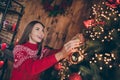 Photo of dreamy shiny young lady wear red pullover smiling decorating christmas tree indoors house home room