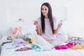 Photo of dreamy shiny young woman nightwear sitting bed holding modern gadget choosing what wear inside indoors home Royalty Free Stock Photo