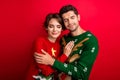 Photo of dreamy sleepy married couple wear ornament sweaters embracing closed eyes isolated red color background