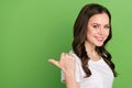 Photo of dreamy sweet woman dressed white t-shirt pointing thumb back empty space isolated green color background