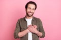 Photo of dreamy sweet young guy dressed brown shirt smiling arms chest isolated pink color background