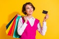 Photo of dreamy sweet young lady wear pink suit holding bargains bank card looking empty space yellow color