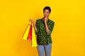 Photo of dreamy unsure trans human wear smart casual clothes holding bargains looking empty space isolated yellow color