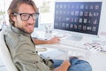 Photo editor turning and smiling at his desk