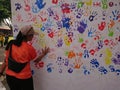 Photo editorial, woman give a hand stamp using paint at backdrop