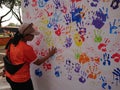 Photo editorial, woman give a hand stamp using paint at backdrop