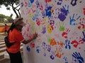 Photo editorial, woman give a hand stamp using paint at backdrop