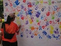 Photo editorial, woman give a hand stamp using paint at backdrop