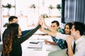 Photo editors giving high-five in meeting room at creative office Royalty Free Stock Photo