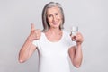 Photo of elderly woman happy positive smile show thumb-up like cool choice drink water isolated over grey color Royalty Free Stock Photo