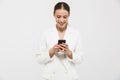 Photo of elegant businesswoman 20s wearing elegant jacket smiling while typing on cell phone