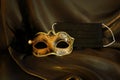 Photo of elegant and delicate gold Venetian mask over black silk background. Coronavirus prevention concept Royalty Free Stock Photo