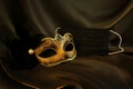 Photo of elegant and delicate gold Venetian mask over black silk background. Coronavirus prevention concept Royalty Free Stock Photo