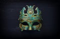 Photo of elegant and delicate Greek or Roman gold with blue Venetian mask over dark wooden background Royalty Free Stock Photo