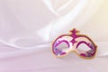 Photo of elegant and delicate pink, purple and gold venetian mask over white silk background. Royalty Free Stock Photo