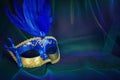 Photo of elegant and delicate Venetian mask over blue dark chiffon background