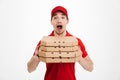 Photo of emotional guy from delivery service in red t-shirt and Royalty Free Stock Photo