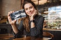 Emotional happy beautiful young pretty woman sitting in cafe indoors using mobile phone talking with friends take a selfie Royalty Free Stock Photo