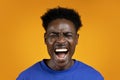 Photo of emotional screaming young african man on yellow Royalty Free Stock Photo