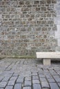 Empty stone bench against a brick wall Royalty Free Stock Photo