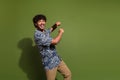 Photo of energetic mexican curly hair guy in stylish outfit dancing boogie woogie clubber have fun isolated on khaki