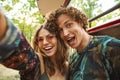 Photo of european hippie couple man and woman smiling, and taking selfie in forest near retro minivan Royalty Free Stock Photo