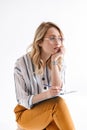 Photo of european thinking woman wearing glasses sitting in chair and looking aside Royalty Free Stock Photo