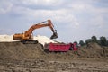 Photo of excavator and dumper truck. Construction site digger. Industrial machinery on building site.