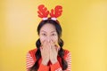 Portrait of cheerful happy asian girl wearing christmas deer costume standing isolated on yellow background, copy space. Royalty Free Stock Photo