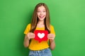 Photo of excited brown hair teenager girl wear orange t-shirt hold red paper like symbol popular blogger surprised