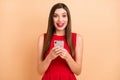 Photo of excited brunette charming woman hold phone message reaction sale isolated on pastel beige color background