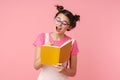 Photo of excited charming girl in eyeglasses writing in exercise book