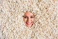 Photo of excited cheerful young girl head curious stick out looking through round hole covering salty pop corn enjoying
