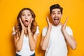 Photo of excited couple man and woman in basic clothing shouting