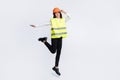 Photo of excited crazy builder lady girlish jump wear helmet shirt vest trousers shoes isolated white color background